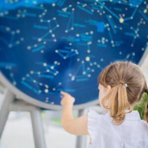 An image of a young child looking at constellations.