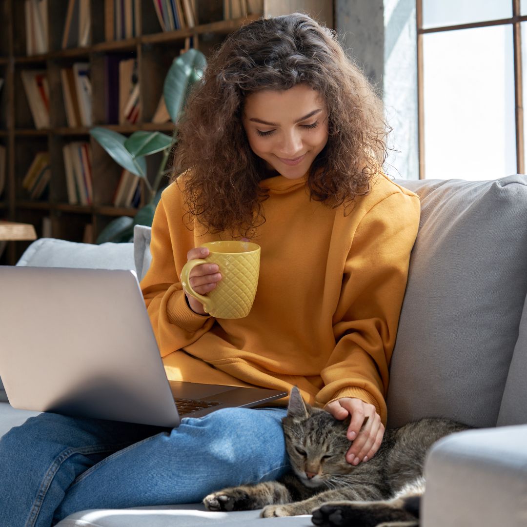 Woman sitting on nice couch petting cat