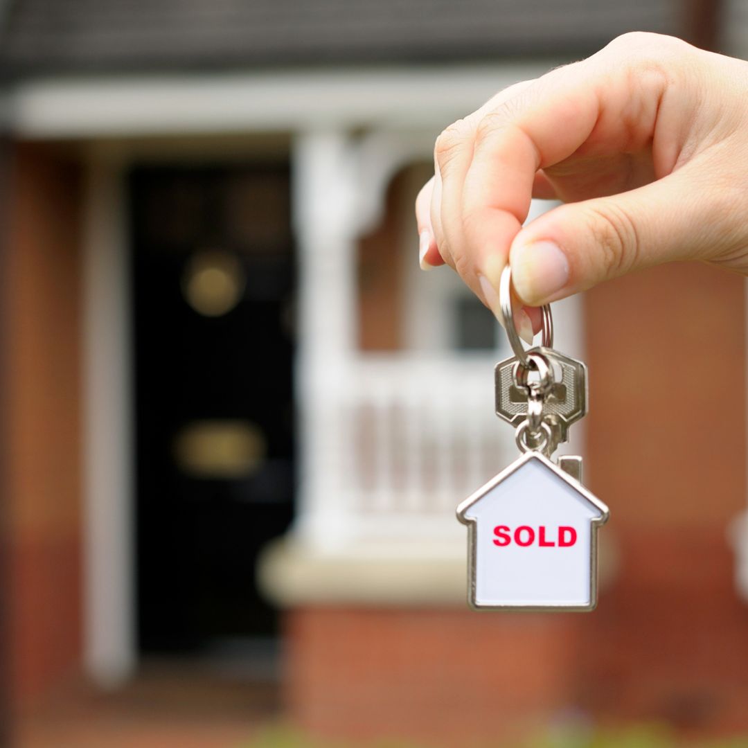 holding keys in front of a home