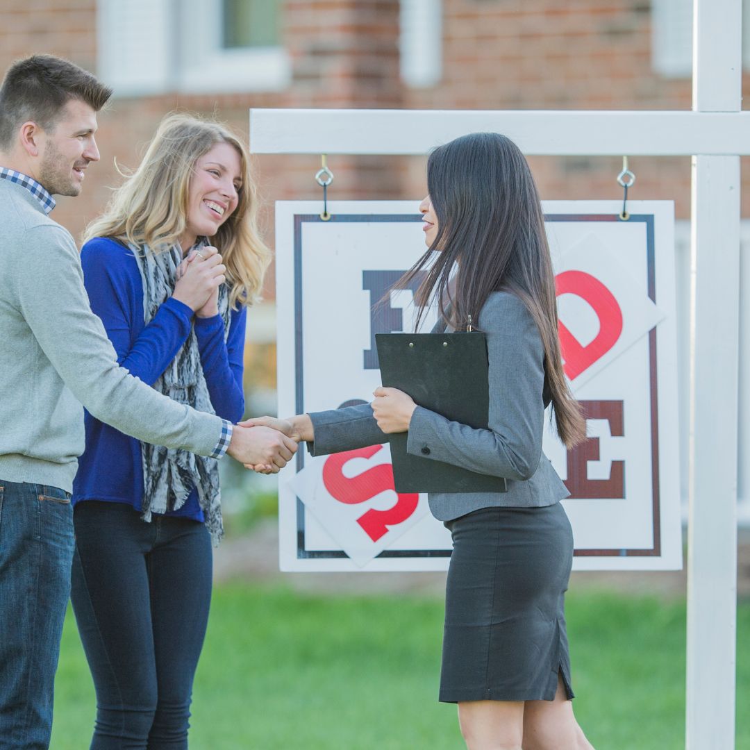 couple shaking hands with real estate agent