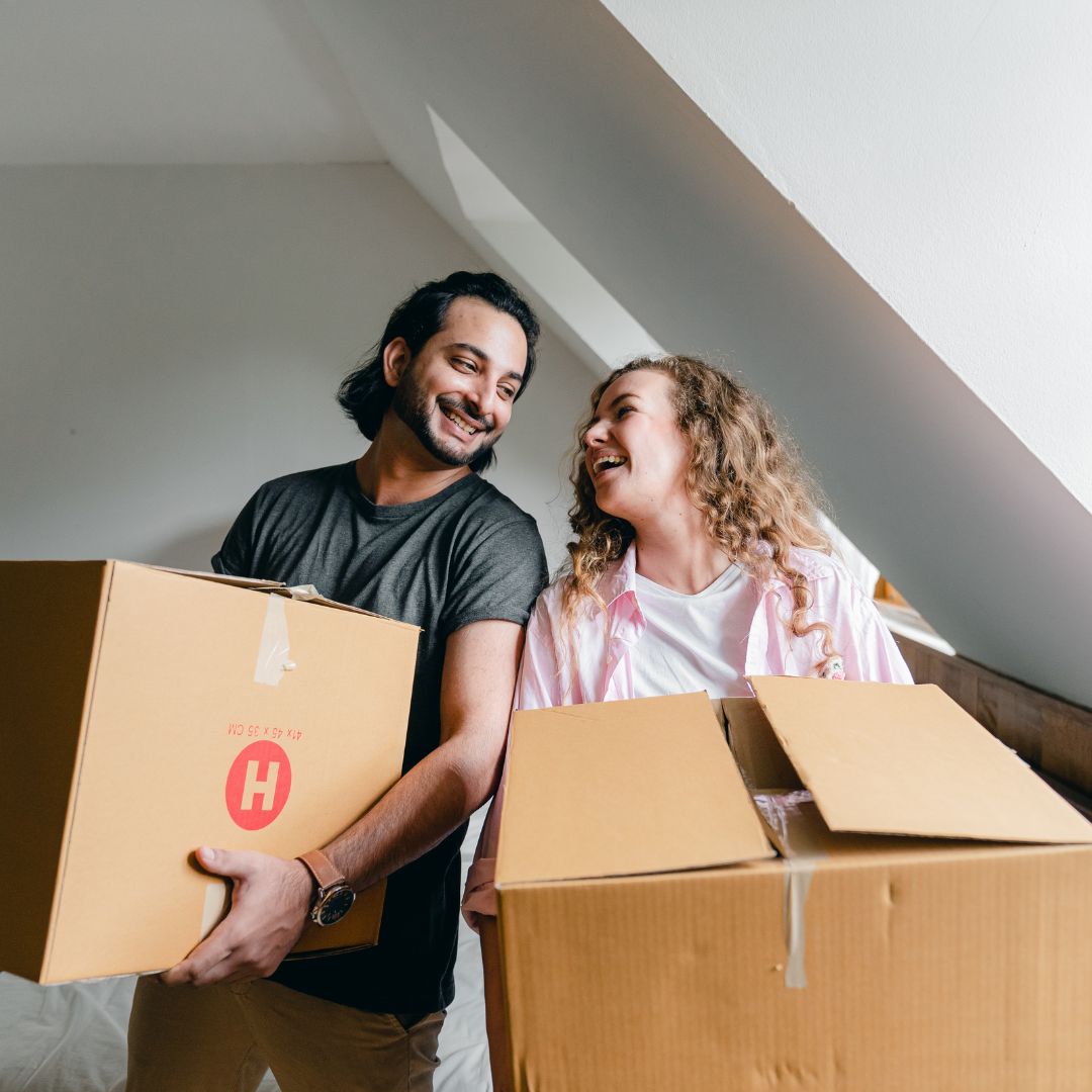 couple holding moving boxes
